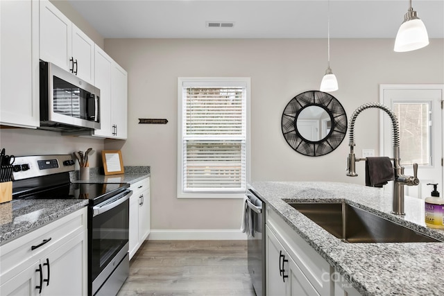 106 Dalton St, Black Mountain, NC 28711 - kitchen featuring appliances with stainless steel finishes, a sink, light wood-style floors, and pendant lighting