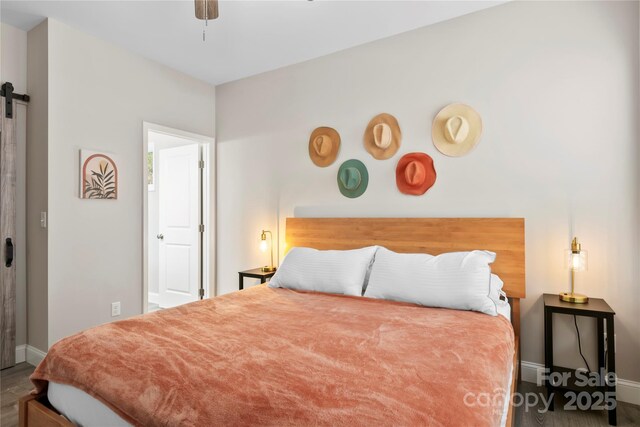106 Dalton St, Black Mountain, NC 28711 - bedroom with baseboards, a barn door, wood finished floors, and a ceiling fan