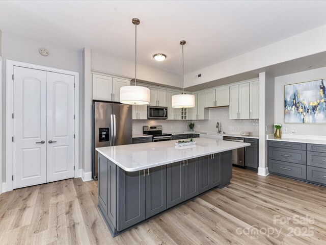4625 Piedmont Row Dr Unit 410, Charlotte, NC 28210 - kitchen with stainless steel appliances, gray cabinets, a kitchen island, and light wood-style flooring