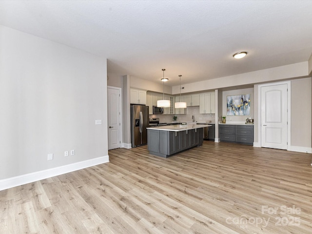 4625 Piedmont Row Dr Unit 410, Charlotte, NC 28210 - kitchen featuring stainless steel appliances, light countertops, gray cabinetry, a center island, and baseboards