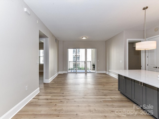 4625 Piedmont Row Dr Unit 410, Charlotte, NC 28210 - unfurnished living room with baseboards and light wood-style flooring