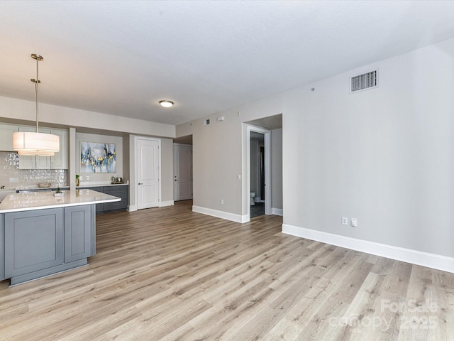 4625 Piedmont Row Dr Unit 410, Charlotte, NC 28210 - kitchen featuring gray cabinets, light countertops, light wood finished floors, and baseboards