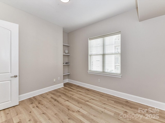 4625 Piedmont Row Dr Unit 410, Charlotte, NC 28210 - unfurnished room featuring wood finished floors, baseboards, and built in shelves