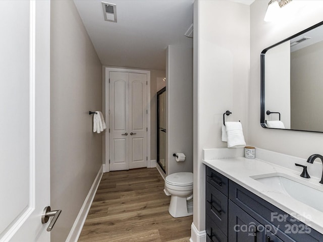 4625 Piedmont Row Dr Unit 410, Charlotte, NC 28210 - bathroom with vanity, toilet, wood finished floors, a stall shower, and baseboards