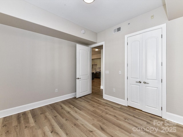 4625 Piedmont Row Dr Unit 410, Charlotte, NC 28210 - unfurnished bedroom with light wood-type flooring, baseboards, and a closet