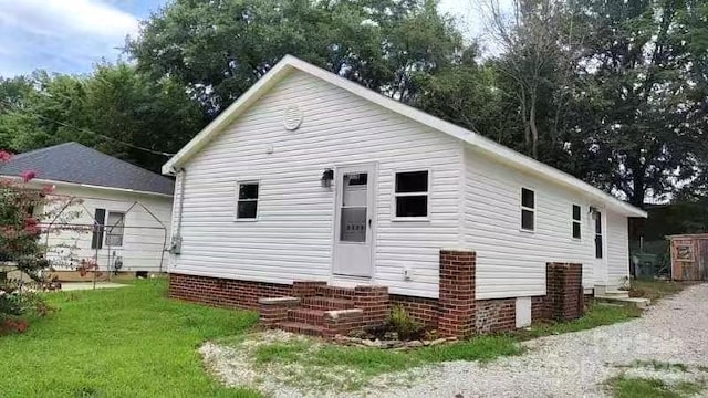 rear view of property with a yard and entry steps