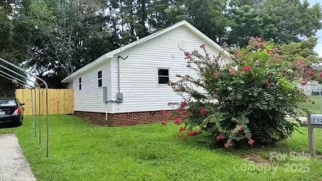 view of property exterior featuring a lawn and fence