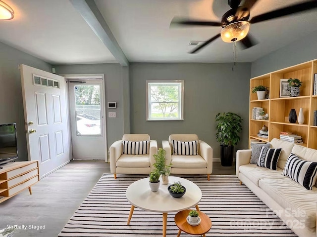 living room with a ceiling fan, visible vents, and wood finished floors