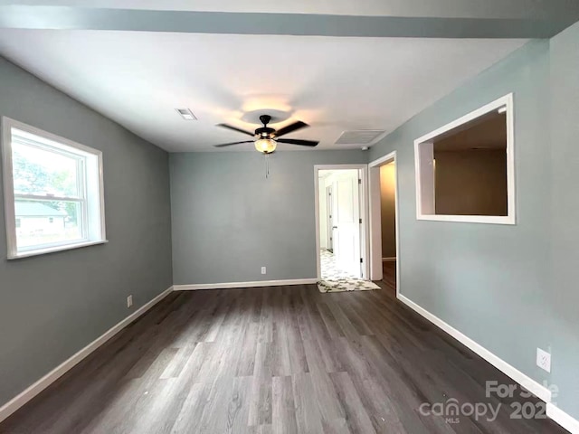 spare room with baseboards, ceiling fan, wood finished floors, and visible vents