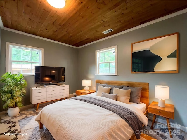 bedroom featuring baseboards, visible vents, ornamental molding, and multiple windows