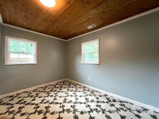 spare room featuring crown molding, carpet floors, baseboards, wooden ceiling, and visible vents