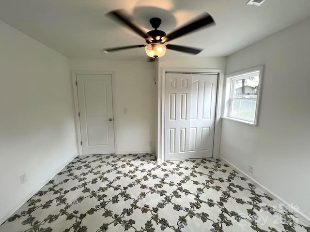 unfurnished bedroom with baseboards, a ceiling fan, tile patterned floors, and a closet