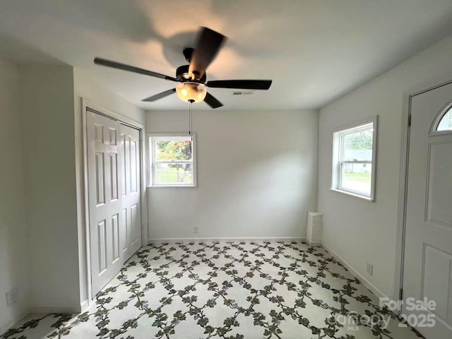 unfurnished bedroom featuring baseboards and multiple windows