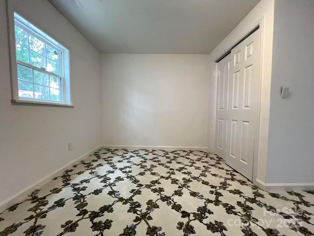 unfurnished bedroom featuring baseboards and a closet