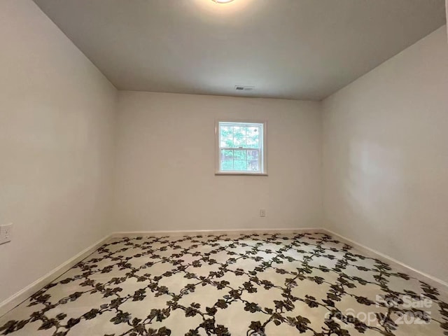 empty room with baseboards and visible vents