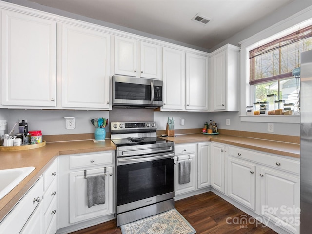 6909 Dunton St, Huntersville, NC 28078 - kitchen featuring visible vents, light countertops, white cabinets, stainless steel appliances, and dark wood-type flooring