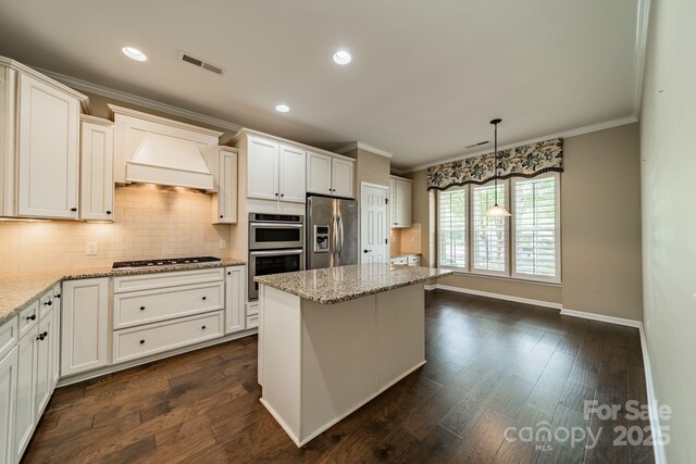 kitchen featuring crown molding, backsplash, appliances with stainless steel finishes, and custom exhaust hood