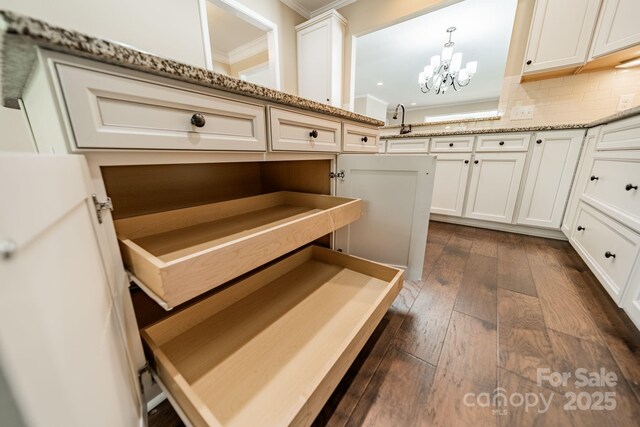 interior space featuring crown molding, an inviting chandelier, dark wood-style floors, recessed lighting, and white cabinets