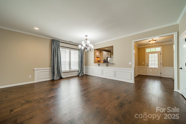 unfurnished room with ornamental molding, dark wood-style floors, recessed lighting, a wainscoted wall, and a notable chandelier