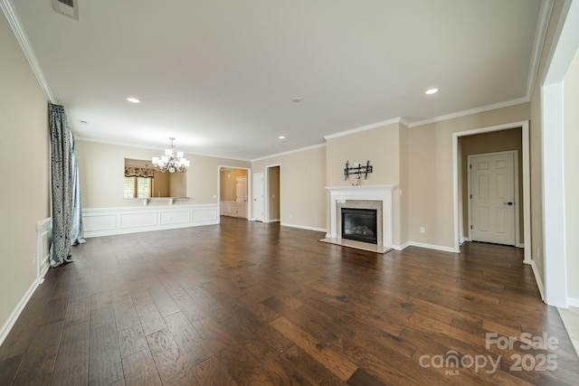 unfurnished living room with visible vents, a premium fireplace, a notable chandelier, ornamental molding, and dark wood-type flooring