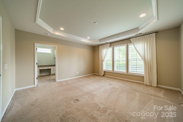 spare room with recessed lighting, baseboards, light carpet, and a raised ceiling