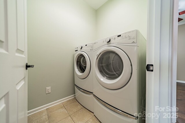 clothes washing area with light tile patterned floors, baseboards, laundry area, and independent washer and dryer