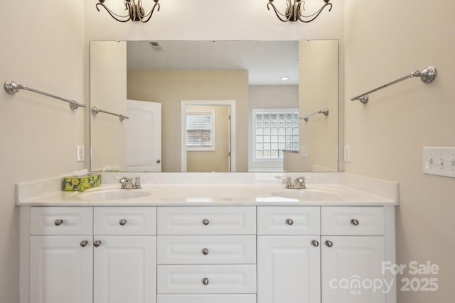 full bath featuring a sink, double vanity, and a chandelier