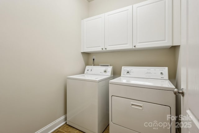 laundry area featuring baseboards, washing machine and dryer, and cabinet space