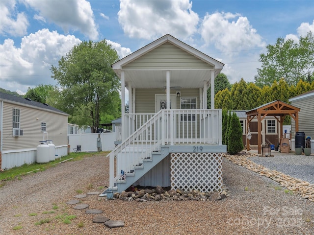 219 Pike Pt, Waynesville, NC 28785 - shotgun-style home with a porch, fence, stairs, a storage unit, and an outbuilding