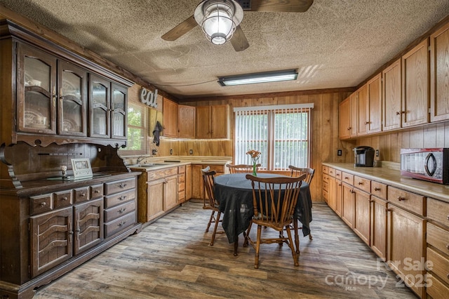 1533 Mcrary Creek Rd, Lenoir, NC 28645 - kitchen featuring dark wood-style floors, wooden walls, ceiling fan, a sink, and a textured ceiling