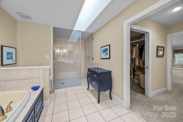 full bath featuring baseboards, a bath, a stall shower, and visible vents