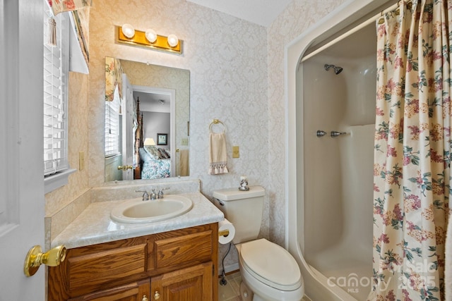 full bathroom featuring vanity, a stall shower, wallpapered walls, and toilet