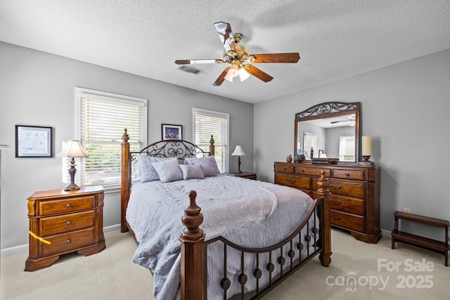 bedroom featuring a textured ceiling, ceiling fan, and light carpet