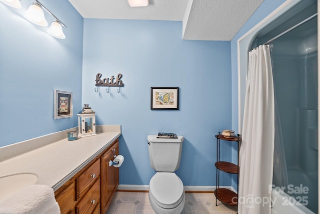 bathroom with vanity, tile patterned flooring, toilet, baseboards, and a textured ceiling