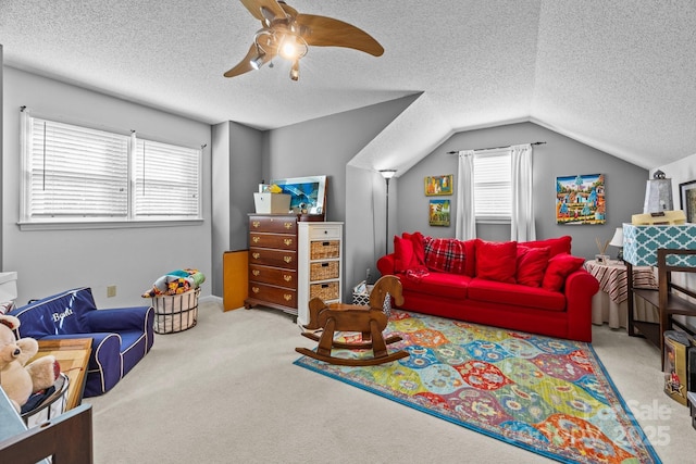 carpeted living room with ceiling fan, a textured ceiling, and lofted ceiling