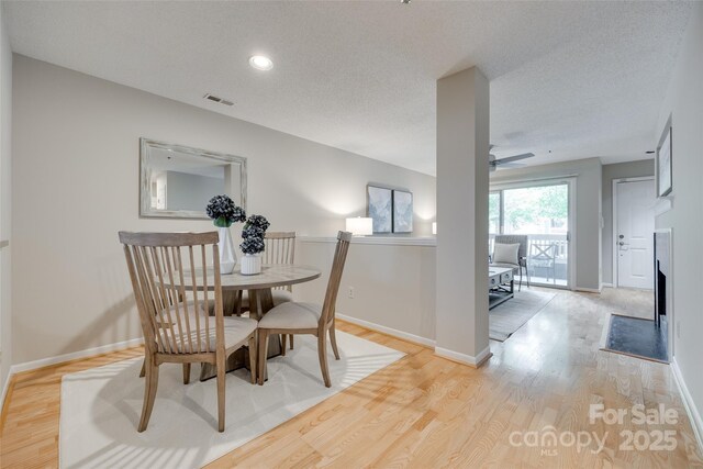 dining area featuring light wood-type flooring, baseboards, a ceiling fan, recessed lighting, and a textured ceiling