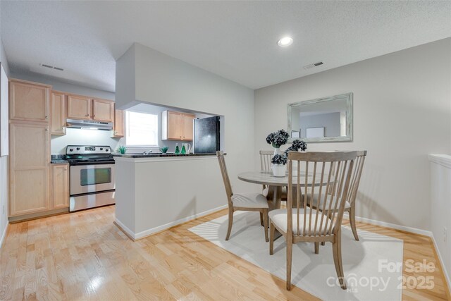 dining area with light wood-type flooring, baseboards, and recessed lighting