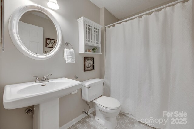 full bathroom with toilet, a sink, baseboards, and a shower with curtain