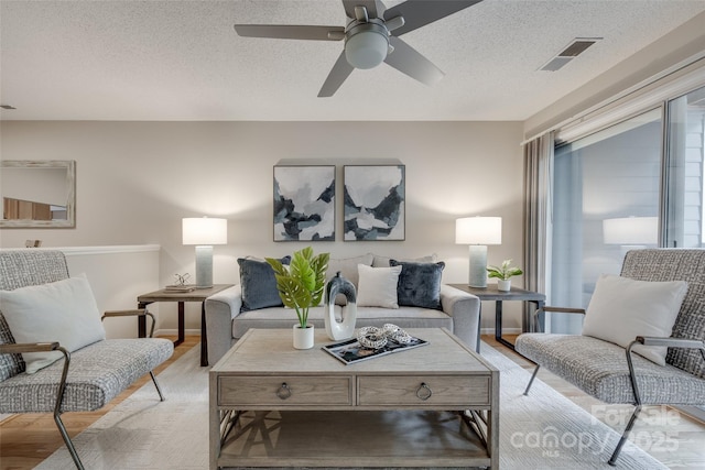2209 Sumner Green Ave Unit M, Charlotte, NC 28203 - living room with light wood-style floors, a ceiling fan, and a textured ceiling
