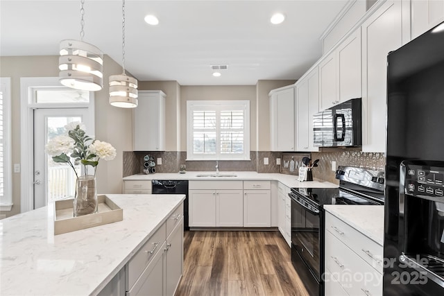kitchen featuring recessed lighting, visible vents, a sink, and black appliances