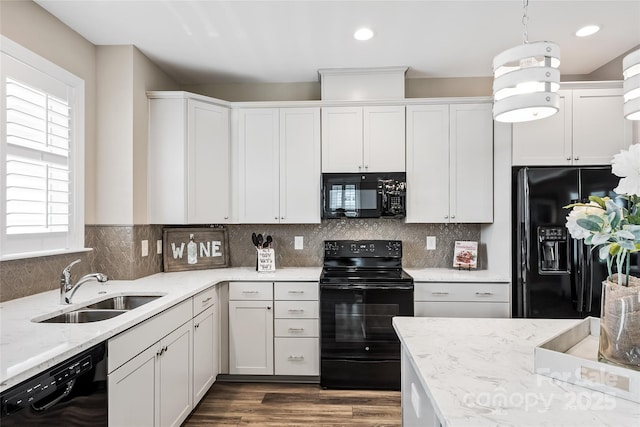 kitchen with white cabinets, light stone countertops, a sink, dark wood-type flooring, and black appliances