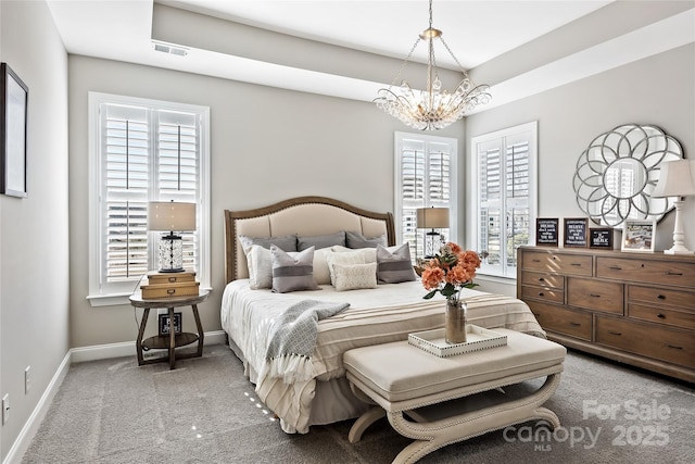 carpeted bedroom with baseboards, a chandelier, and visible vents