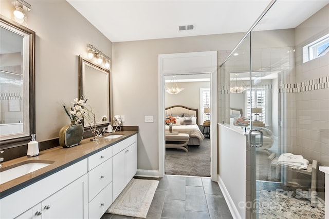 ensuite bathroom with visible vents, connected bathroom, a sink, a stall shower, and a notable chandelier