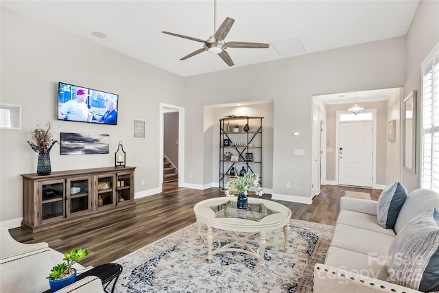 living room with stairway, baseboards, ceiling fan, and wood finished floors