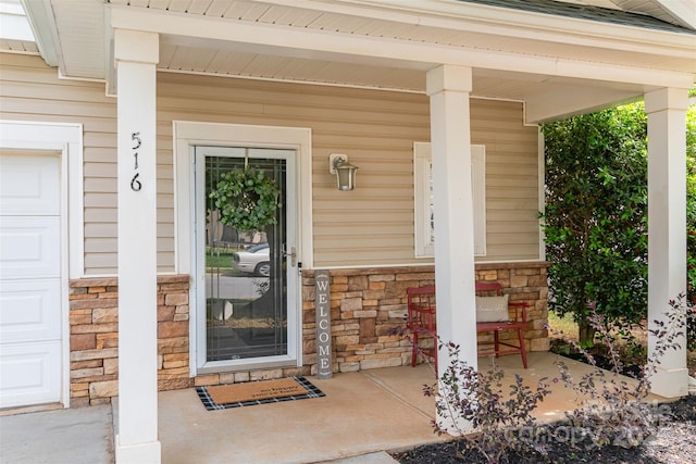 property entrance with covered porch and stone siding