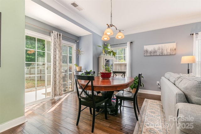 dining area featuring baseboards, ornamental molding, dark wood-style flooring, and visible vents