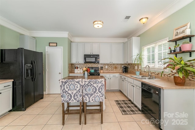 kitchen with visible vents, a sink, black appliances, and ornamental molding