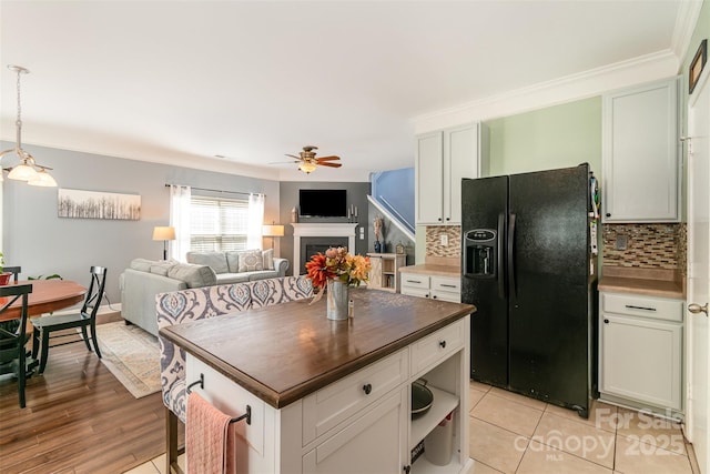 kitchen with a ceiling fan, open floor plan, tasteful backsplash, and black fridge with ice dispenser