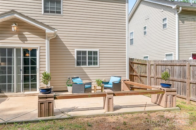 rear view of house featuring fence and a patio area