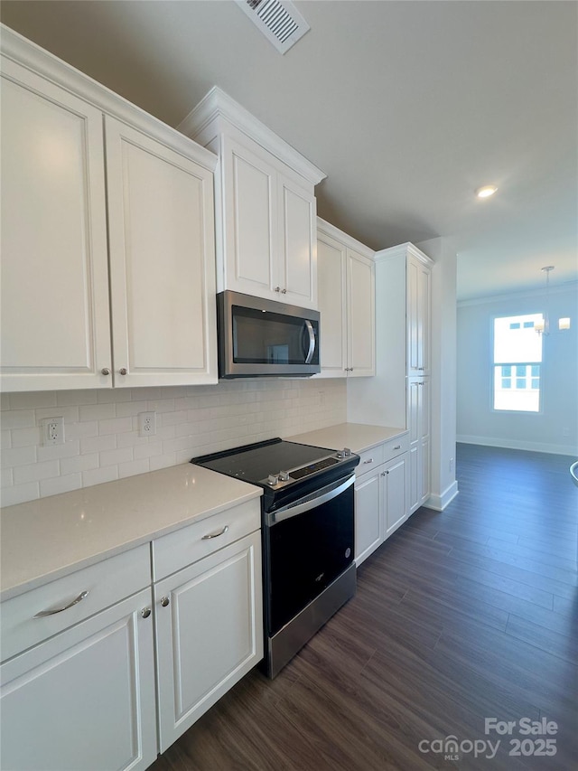 kitchen with stainless steel appliances, backsplash, white cabinets, and dark wood-style flooring